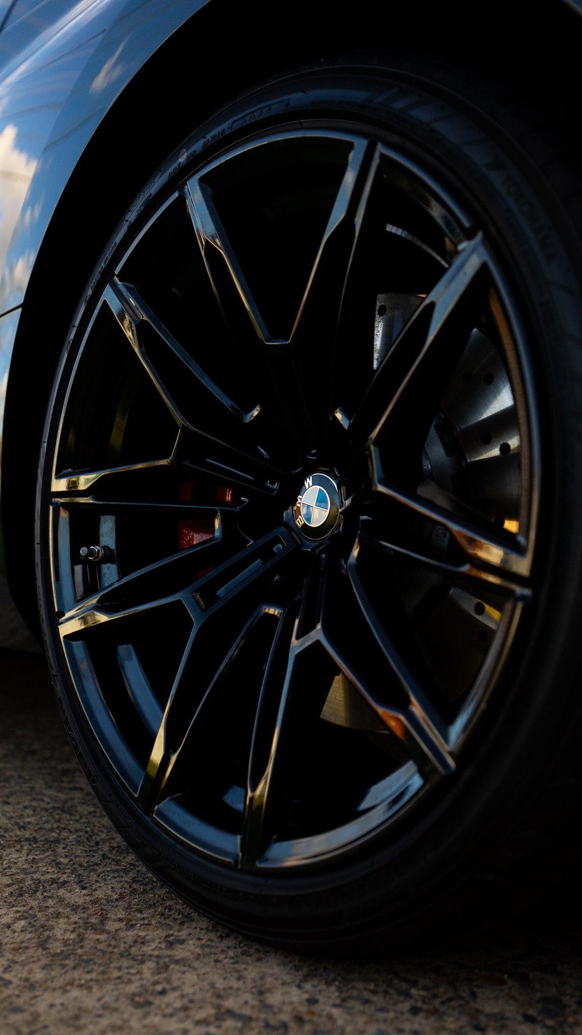 Close-up of a car wheel with a black rim and visible BMW logo.